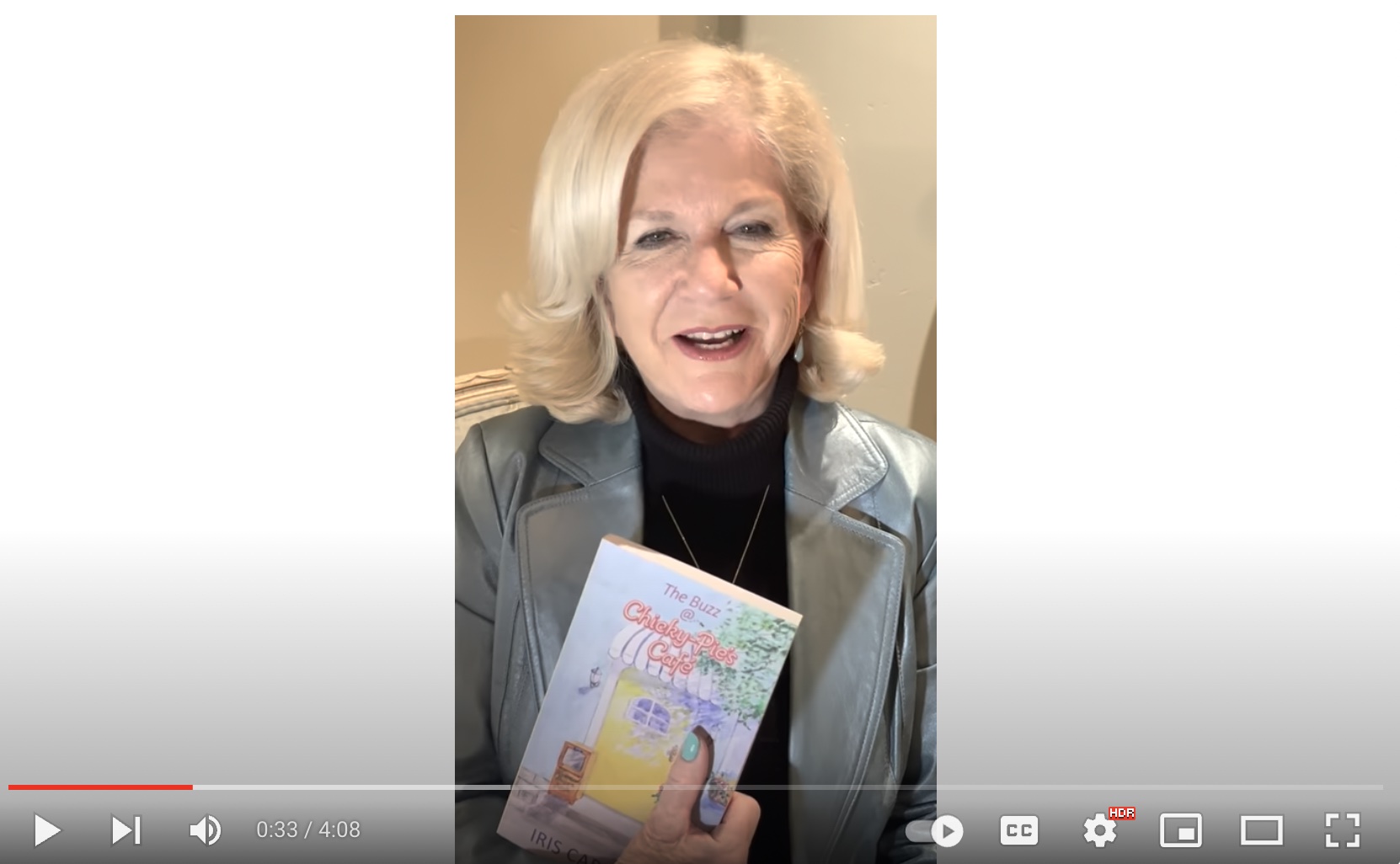 Image of Iris Carignan video on youtube. Iris is holding her book in the video.
